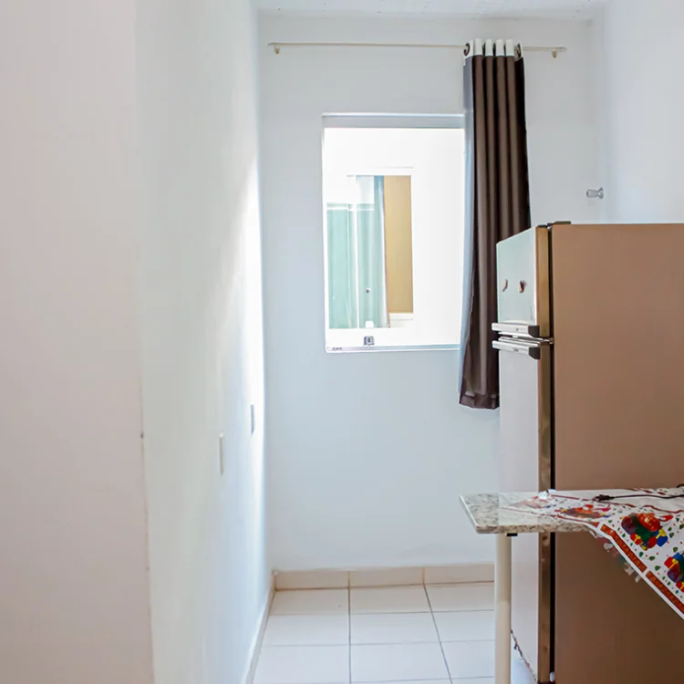 vista de uma janela, uma geladeira e uma mesa pequena