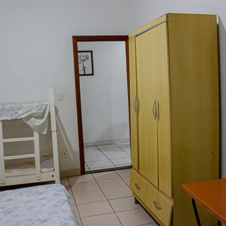 a visao de saida de um quarto onde se ve um beliche um guarda roupa amarelo