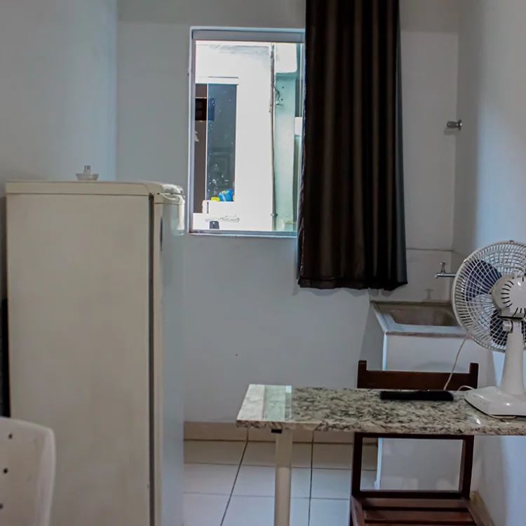 imagem de uma janela uma geladeira e um ventilador