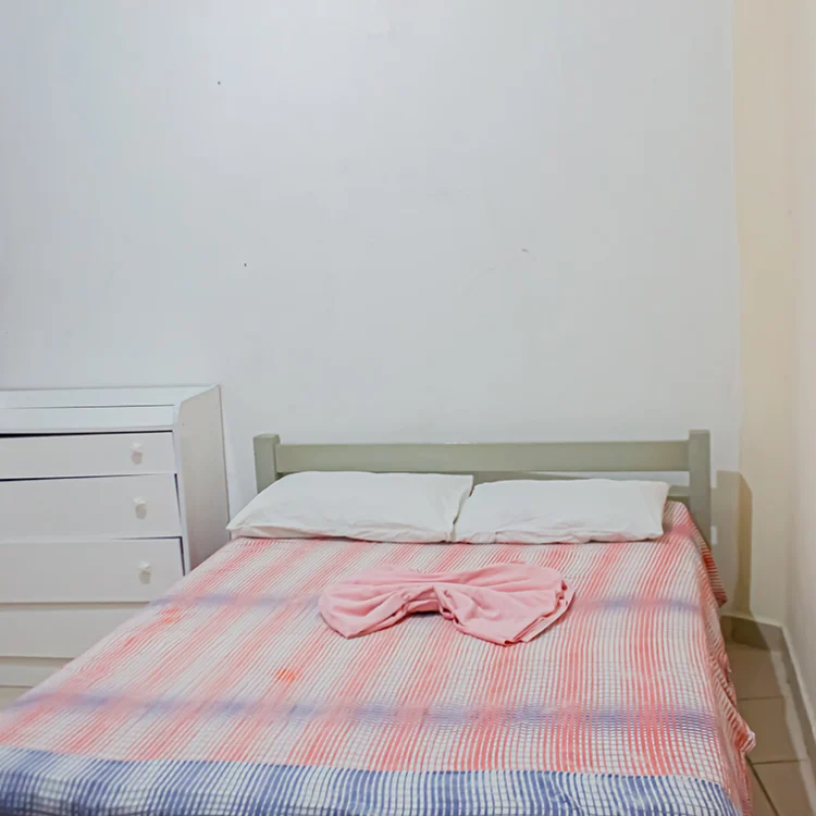 uma cama de casal jundo com uma comoda